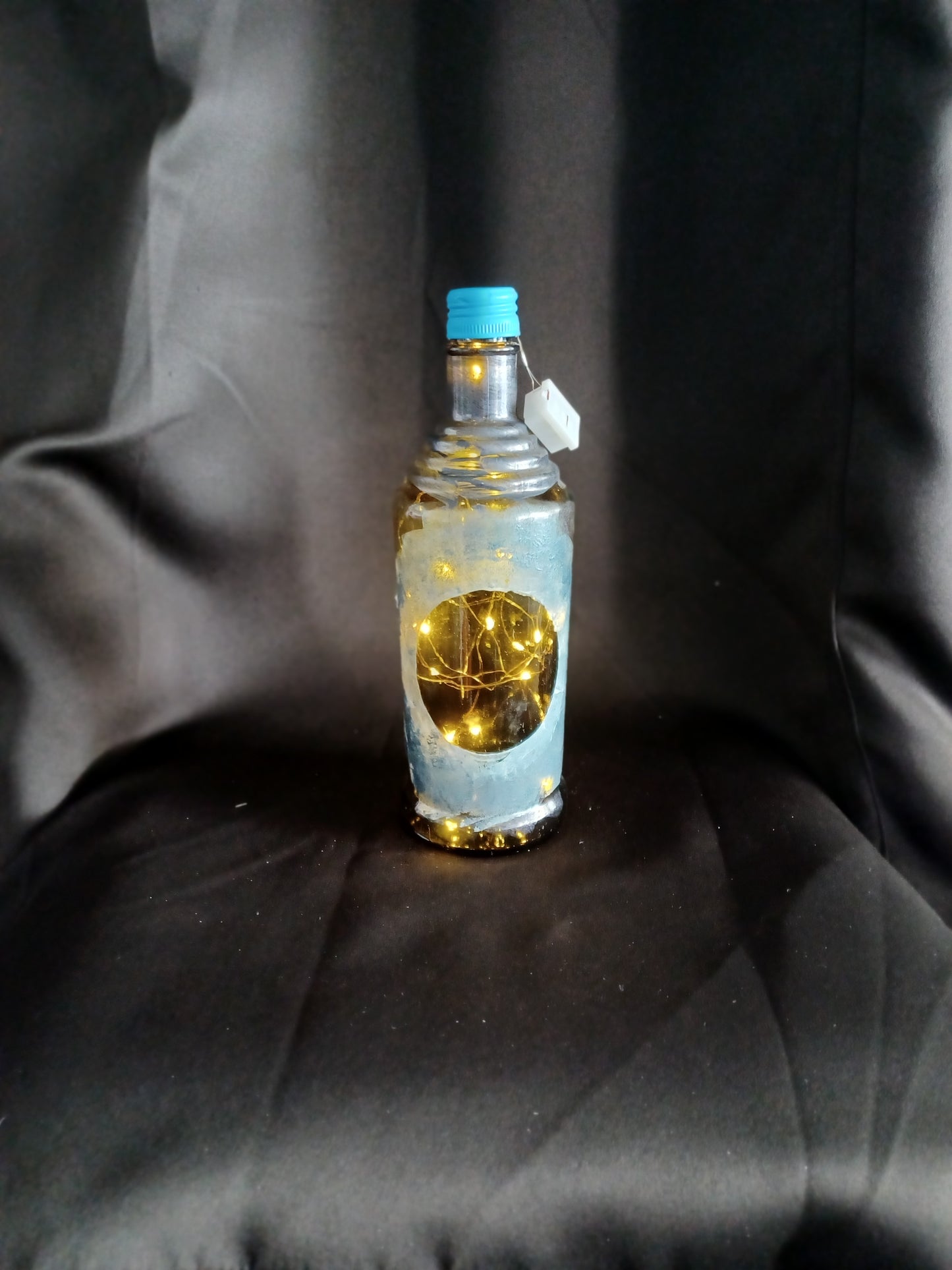 Hand painted amber bottle w/ light blue accents, circle front, fairy lights